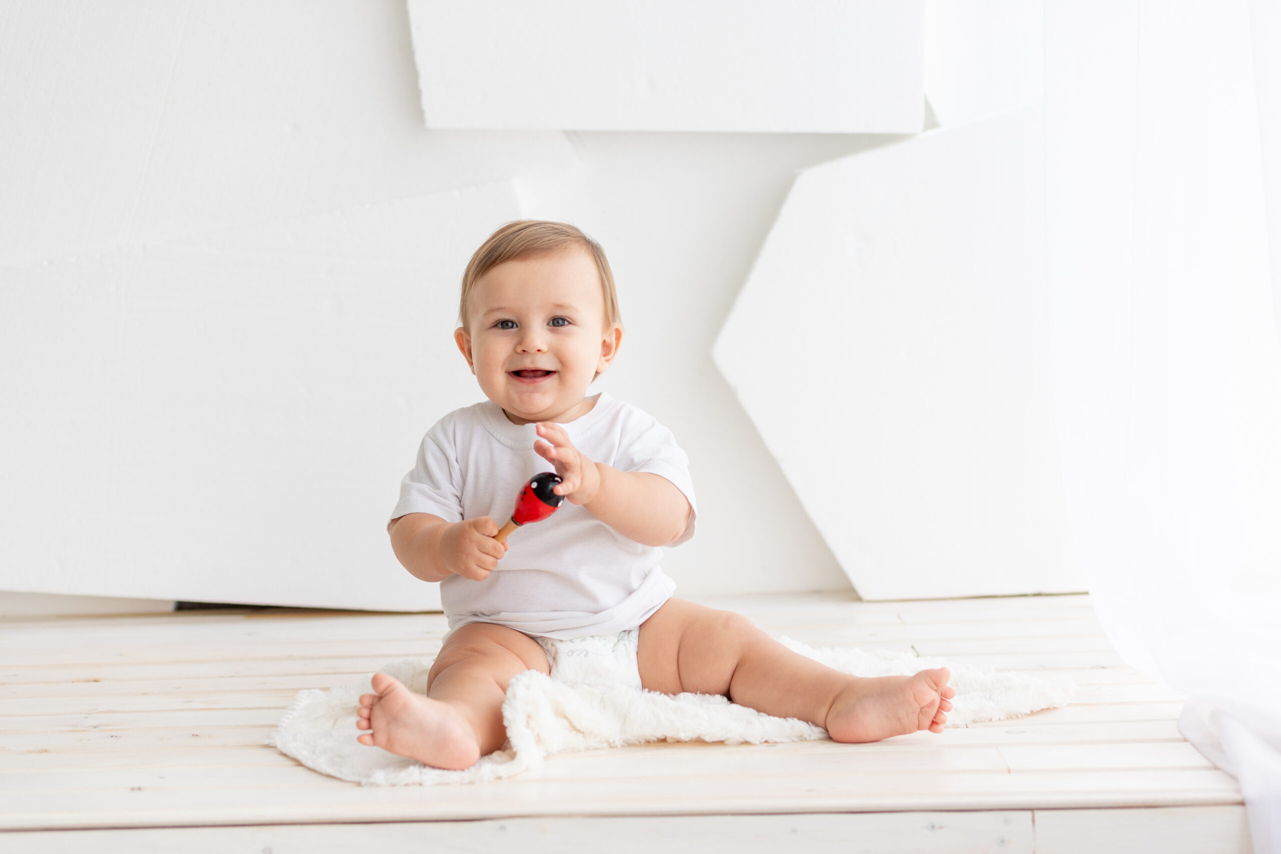 Glad baby leger med maracas. Baby har udviklet evnen til at interagere mere effektivt med ting