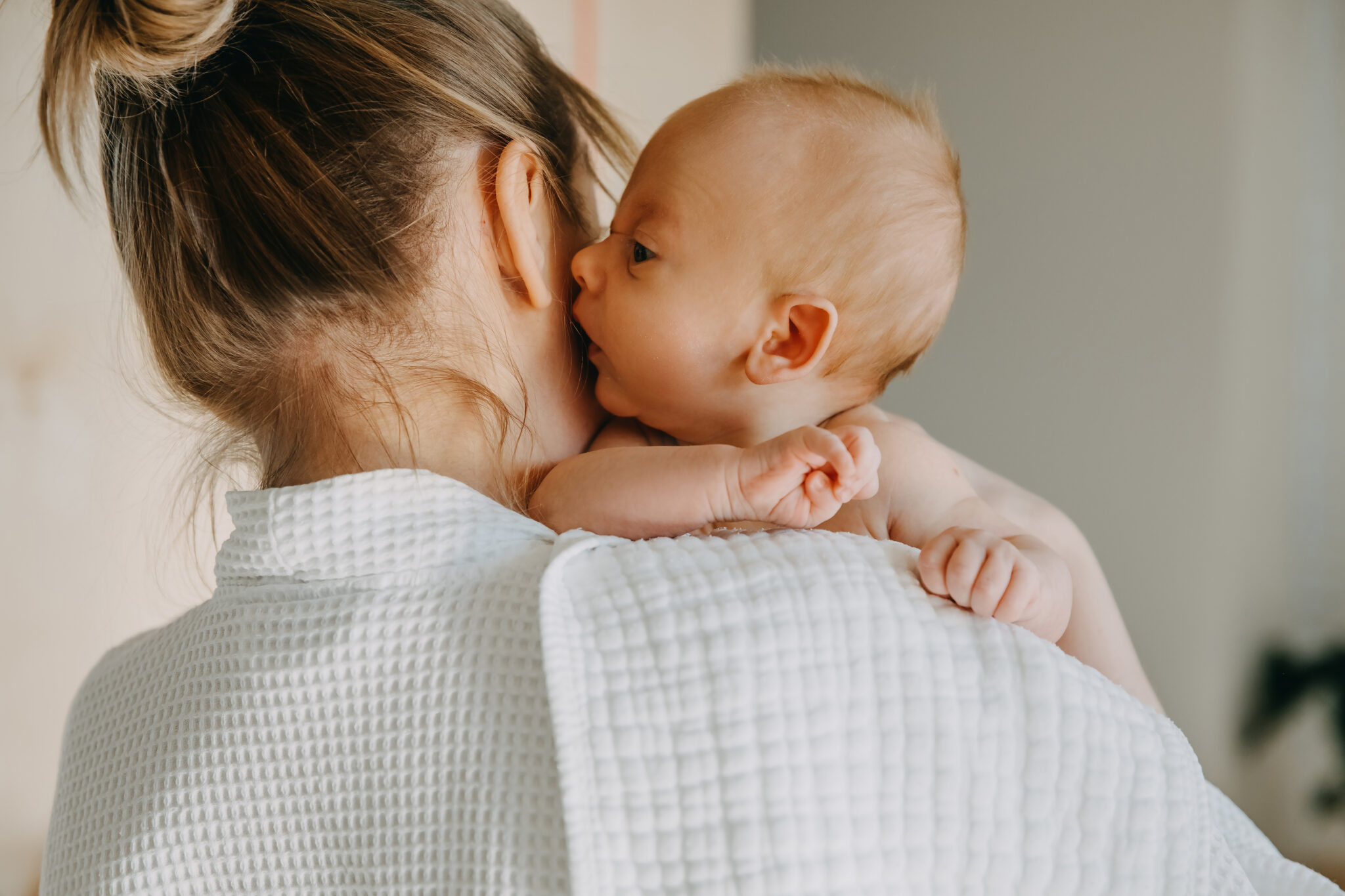 Mor holder nyfødt baby mod skulderen. Gennem sanseintegration oplever barnet at kunne høre